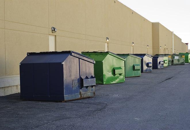 a fleet of red and blue construction dumpsters available for use in Fort Walton Beach